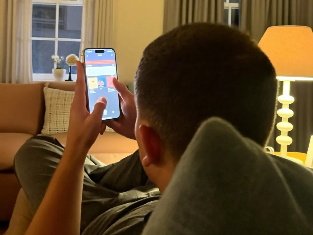 Person relaxing on a sofa, scrolling on a phone